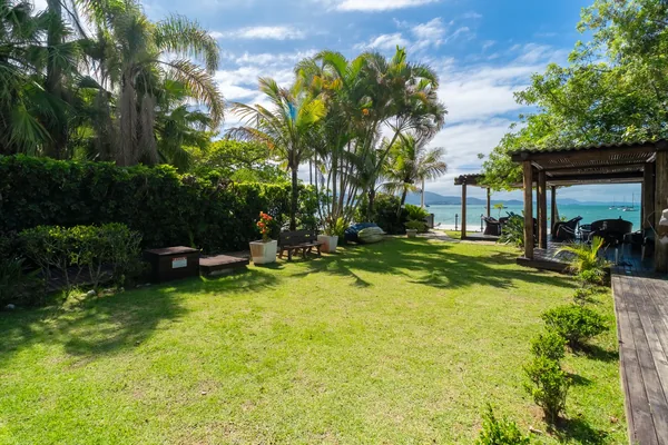 Jardim e área de gramado com vista para o mar